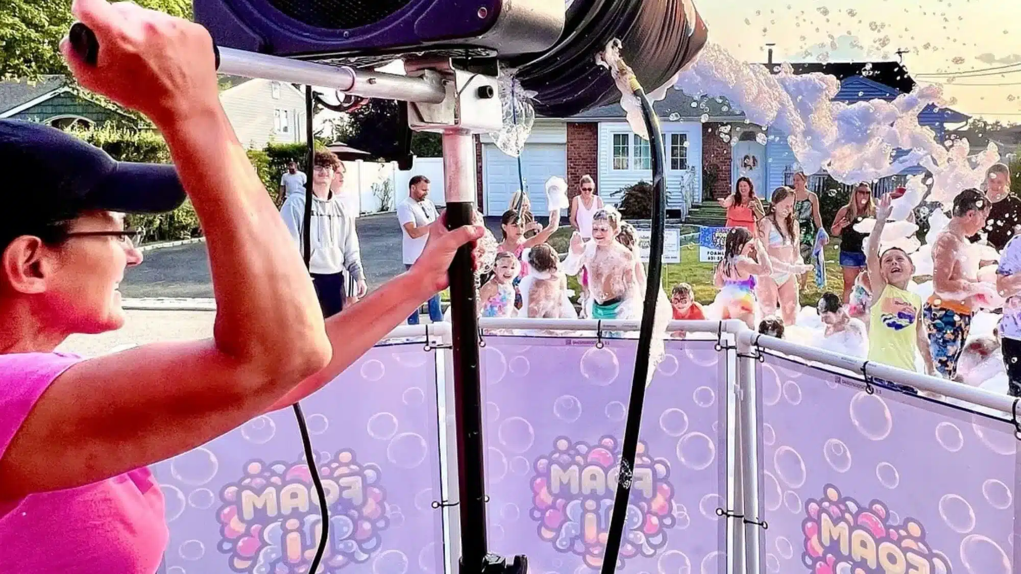 Foam party event setup in backyard with foam machine producing large foam coverage while guests enjoy outdoor celebration