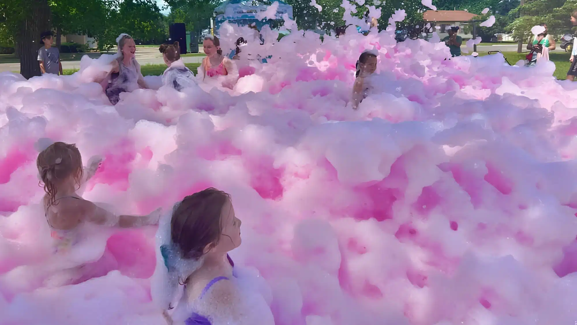 Happy children playing in a foam pit outdoors together