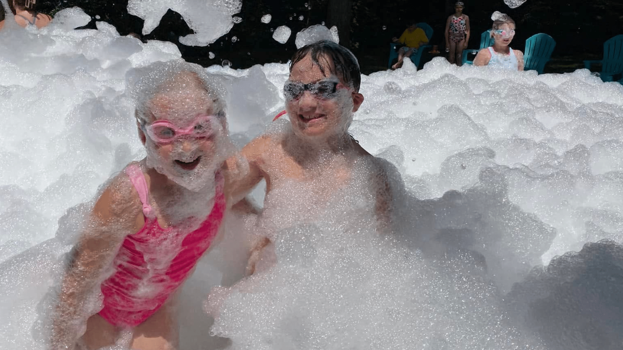 Children laughing and playing in a foam filled party area